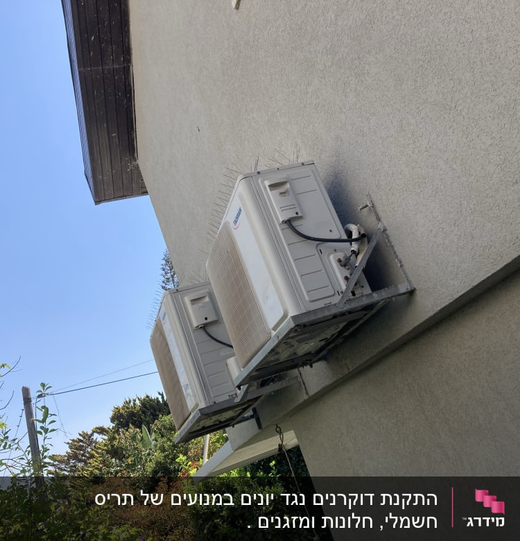 שני מזגנים מותקנים על קיר עם דוקרנים למניעת יונים